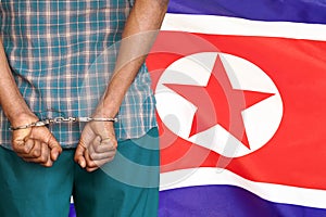 African male with handcuffs on the background of the North Korea flag