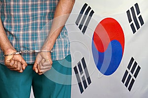 African male with handcuffs on the background of the South Korea flag