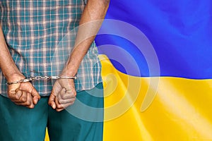 African male with handcuffs on the background of the Ukraine flag