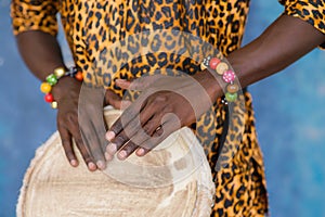 African male hands playing on jembe drum, closeup