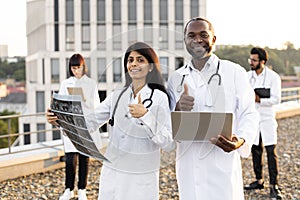 African male with laptop and young Indian female doctor with stethoscope