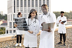 African male with laptop and young Indian female doctor with stethoscope