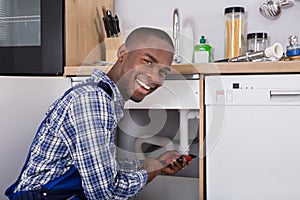 Male Plumber Fixing Sink Pipe