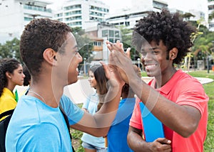 African male student give high five to indian student