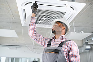 african Male Technician Repairing Air Conditioner.