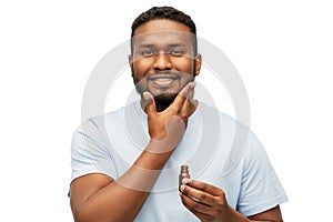 African man applying grooming oil to beard