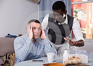 African man asking for forgiveness from offended friend