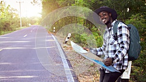 African man with a backpack holding a map to travel