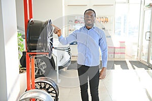 An African man buys car rims in an auto parts store