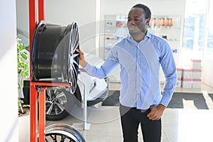 An African man buys car rims in an auto parts store