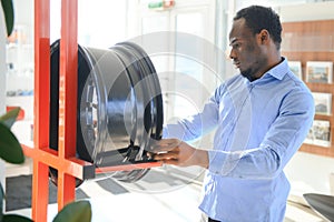 An African man buys car rims in an auto parts store