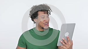 African Man Celebrating Success on Tablet on White Background