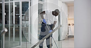 African man, cleaning and mopping office floor with earphones for work or company. Commercial cleaner, service and