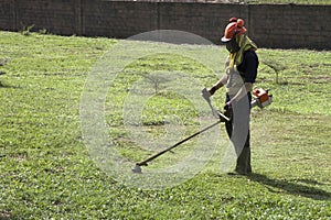 African Man cutting the lawn