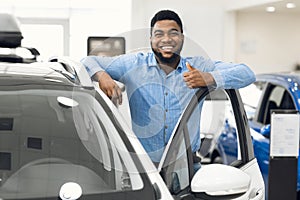 African Man Gesturing Thumbs-Up Approving Automobile After Test-Drive In Dealership
