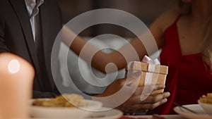 African Man Giving Gift To Female Having Date In Restaurant