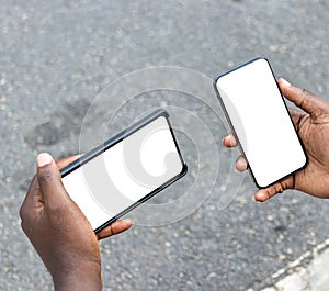 African man hands holding two smartphone with blank space screen for your texting or news content