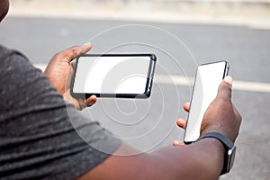 African man hands holding two smartphone with blank space screen for your texting or news content