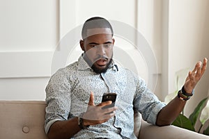 African man holds cellphone read sms feels shocked