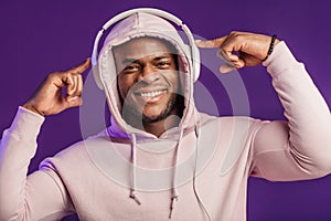 African man in hoodie with headphones isolated, happy expression. Music, people