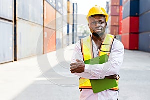 African man industrial worker standing, arm crossed works at a container yard. Shipping business management and international