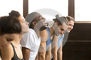 African man laughing doing yoga or plank at group training