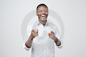 African man laughing and pointing finger at you.
