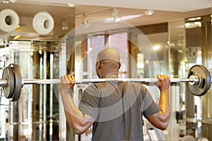 African man lifting a barbell. Back view