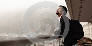 African man looks at clouds with displeasure, nasty weather, poor forecast