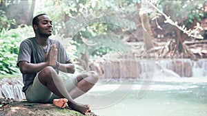 African man meditate spiritual peaceful praying and wishing in green nature