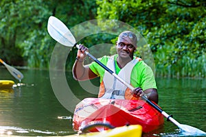 African Man paddling with canoe on river