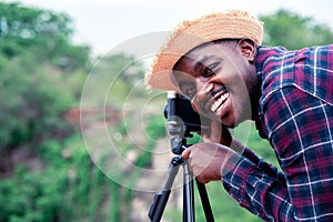 African man photograpy taking the camera and tripod with smiling and happy photo