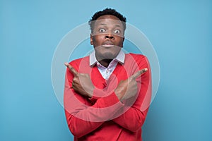 African man pointing in two different directions, not sure which way to go
