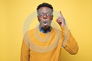 African man pointing upwards showing idea or eureka gesture.