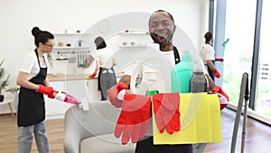 African man professional cleaning worker holding a bucket with detergents.
