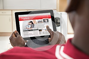 African Man Reading News On Digital Tablet