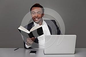 African man reading a novel