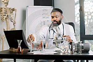 African man scientist researcher sitting at the table in lab and doing dna test, analisys of blood samples or new