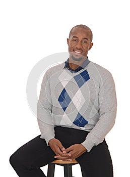 African man sitting on a bar chair smiling