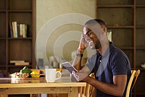 African man sitting at home using digital tablet