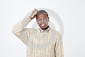 african man in sweater thinking scratching head on white background. How is it supposed to be done concept photo