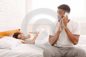 African man talking with mistress at home, hiding from his wife