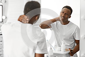African Man Touching Aching Neck Suffering From Pain In Bathroom