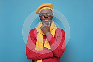 African man touching his chin, looking thoughtful and skeptical about something
