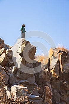 African Man traveler with film camera  standing on top of a mountain and looking at fly seagull