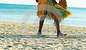 African man tribal dressed walks along beach