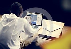 African man using smart phone and computer
