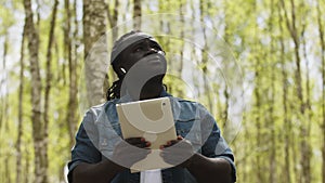 An african man using the tablet in the forest. wireless or future technology concept