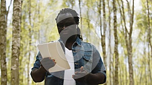 An african man using the tablet in the forest. wireless or future technology concept