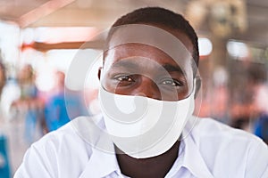 African man wear white shirt and face mask for virus protection with text Pray for the World corona virus or covid-19